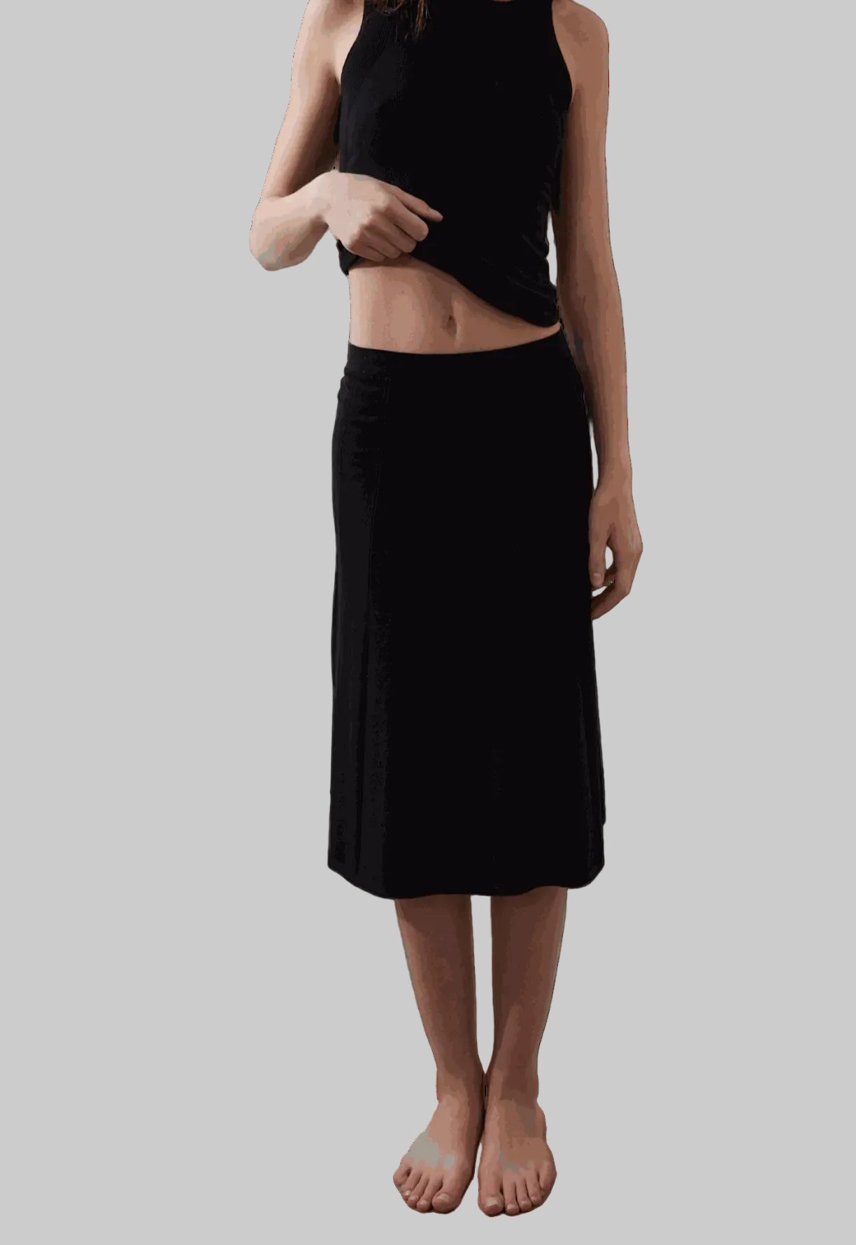 Vega Skirt in black with subtle pleated texture and sleek waist fit.